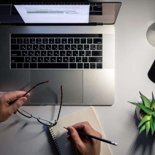 A man works at a laptop at night, night work, deadline, top view.